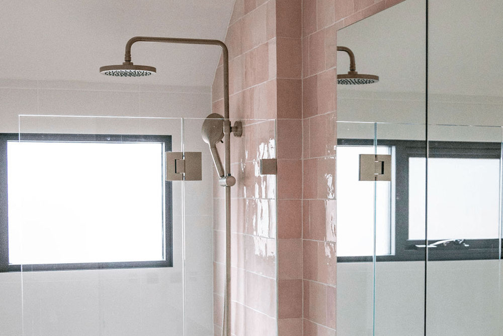 Modern bathroom with dual showerheads and a large mirror.