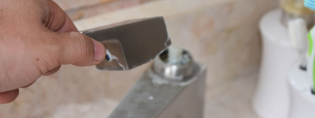 Taking the handle off a bathroom sink tap